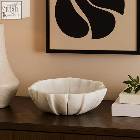 A white marble lotus bowl shaped like petals with smooth polished surface and subtle veining for decor use