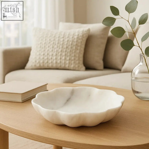 A zoro medium white marble scalloped bowl with a scalloped edge on a wooden table