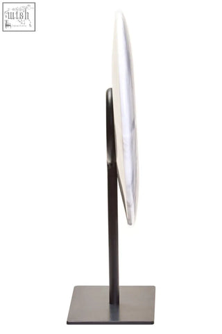 Zoro small round vanity mirror with brushed metallic frame and dark bronze stand paired with white marble disc sculpture